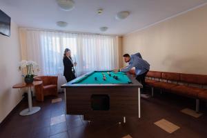 a man and a woman playing a game of billiard at Hotel Grand Felix in Kraków