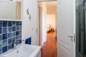 a bathroom with a white sink and blue tiles at Villa Marazia with Garden and Private Parking! in Trecastagni +29 photos
