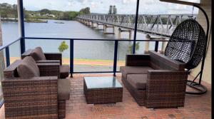 a balcony with two chairs and a table and a bridge at Taree Motor Inn in Taree