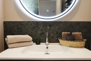 a bathroom sink with a mirror and towels at Picobello Lago in Mandello del Lario