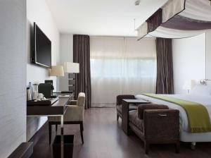 ein Hotelzimmer mit einem Bett und einem Schreibtisch in der Unterkunft NH Collection Santiago de Compostela in Santiago de Compostela