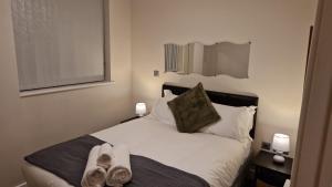 ein Schlafzimmer mit einem Bett mit zwei Handtüchern darauf in der Unterkunft Birmingham Amethyst, 3 bedroom Apartment in Birmingham