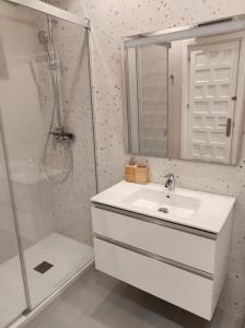 La salle de bains blanche est pourvue d'un lavabo et d'une douche. dans l'établissement HACIENDA 36 MENYBER, à Nerja
