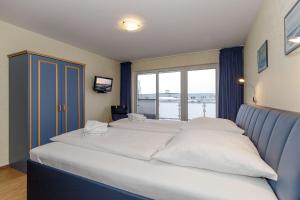 キュールングスボルンにあるYachthafenresidenz-Wohnung-9309-906の窓付きの客室で、白い大型ベッド1台が備わります。