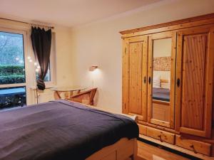 ein Schlafzimmer mit einem großen Holzschrank und einem Bett in der Unterkunft Appartementhaus Residenz Duenengarten in Kühlungsborn