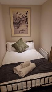 ein Schlafzimmer mit einem Bett mit Handtüchern darauf in der Unterkunft Birmingham Amethyst, 3 bedroom Apartment in Birmingham