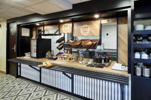 a bakery with a counter with food on it at B&B HOTEL Paris Nord Gonesse Parc des Expos in Gonesse