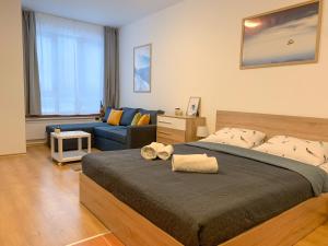 波羅維茨的住宿－Studios and Apartments - Semiramida Gardens，一间卧室配有一张大床和一张蓝色的沙发