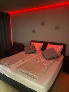Un dormitorio con una cama con luces rojas. en Apartment 1 im Zentrum, Hauptbahnhof, 42103 Wuppertal, en Wuppertal