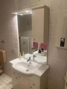 La salle de bains blanche est pourvue d'un lavabo et d'un miroir. dans l'établissement Apartment 1 im Zentrum, Hauptbahnhof, 42103 Wuppertal, à Wuppertal