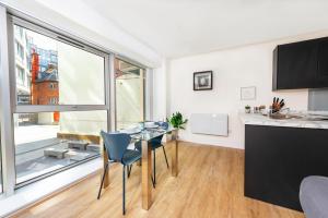 a kitchen and dining room with a table and a large window at Luxury City Centre Apartment - Family Friendly in Liverpool +5 photos