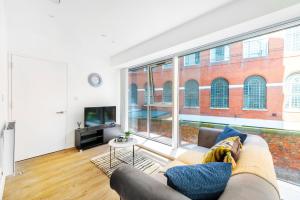 uma sala de estar com um sofá e uma grande janela em Brand New Luxury 1-Bed Apartment in Liverpool em Liverpool