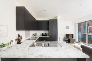 a kitchen with a sink and a counter top at Luxury City Centre Apartment - Family Friendly in Liverpool