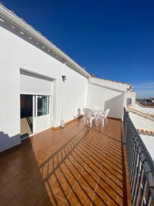 a balcony with tables and chairs on a white house at Casablanca de Almagro in Almagro