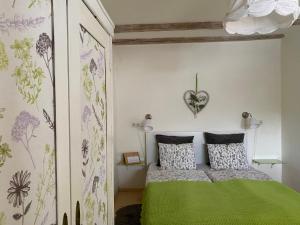 a bedroom with a green bed with a heart on the wall at Traubengarten Winkler in Niederhollabrunn