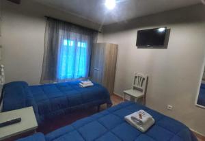 a room with two blue beds and a tv at Cazorla Paraíso Resort in Cazorla