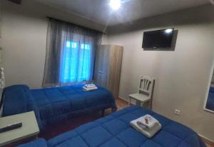 um quarto com duas camas azuis e uma televisão em Cazorla Paraíso Resort em Cazorla