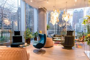 a lobby with furniture and a large window at Motel One Rotterdam in Rotterdam