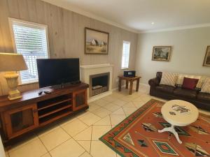 a living room with a flat screen tv and a fireplace at Knysna Self-catering Holiday Home in Knysna +8 photos