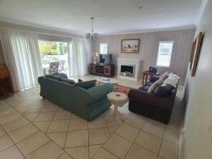 a living room with two couches and a tv at Knysna Self-catering Holiday Home in Knysna
