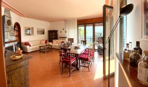 cocina y sala de estar con mesa y sillas en Casa Pescarino con vista lago e idromassaggio, en Oliveto Lario