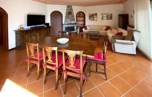 sala de estar con mesa de madera y sillas en Casa Pescarino con vista lago e idromassaggio, en Oliveto Lario
