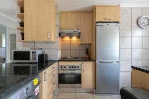 een keuken met een koelkast en een fornuis top oven bij Radstays - 43 Madison Palms in Johannesburg
