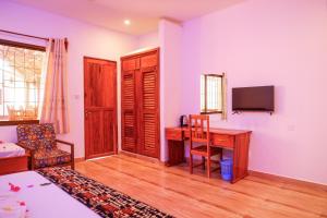 uma sala de estar com uma secretária e uma televisão em Nungwi Heritage Resort em Nungwi