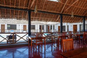 un restaurante con mesas y sillas y vistas al océano en Nungwi Heritage Resort, en Nungwi