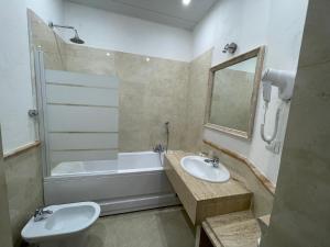 bagno con lavandino, vasca e servizi igienici di Ambasada Suite a Roma