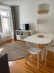 einen weißen Tisch und Stühle im Wohnzimmer in der Unterkunft LX Factory Apartment 1 in Lissabon