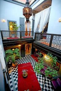 a living room with a red rug and a room with plants at BKAN RIAD MARRAKECH in Marrakech