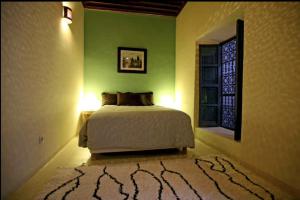 um quarto com uma cama, uma janela e um tapete em BKAN RIAD MARRAKECH em Marrakech