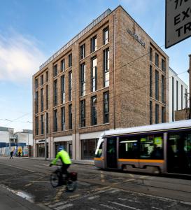 uma pessoa a andar de bicicleta em frente a um edifício em easyHotel Dublin em Dublin