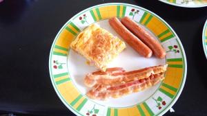 a plate of food with bacon and eggs and sausage at Astra in Agerola