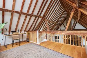 an attic room with a desk and wooden beams at The Coach House, Hambledon in Hambledon