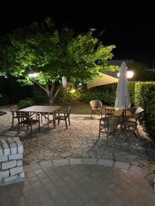 un patio con mesa, sillas y sombrilla en Villa Eugenia in Campomarino di Maruggio, Puglia - casa vacanze, en Campomarino