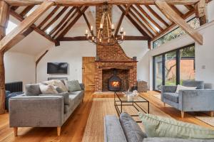 a living room with a fireplace and couches at The Coach House, Hambledon in Hambledon