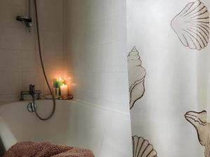 a bathroom with a shower curtain with a candle at Gîte Les 3 Voiles in Ploumilliau