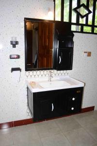 a bathroom with a sink and a mirror at Meremeta Lodge in Utende