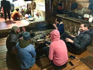 a group of people sitting on the floor in a kitchen at Ba Be lake-Huyền Hào Homestay in Ba Be18