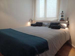 a bedroom with a bed with pillows and a window at Apto 1a línea del Paseo Llafranc con Aire acondicionado Sin Vistas in Llafranc