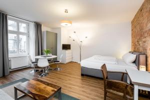 a bedroom with a bed and a desk and a table at stadtRaum-berlin apartments in Berlin