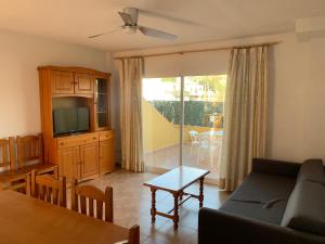 uma sala de estar com um sofá e uma televisão em Kione Anamar em Alcossebre