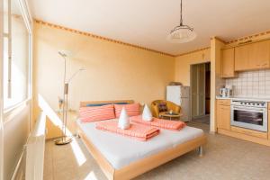 a bedroom with a bed with orange pillows on it at Ferienwohnung Kratzer in Waltenhofen