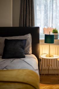 - une chambre avec un lit et une table avec une lampe dans l'établissement Sigmalife Apartment, à Newcastle upon Tyne