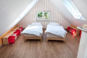 two beds in a attic room with stairs at Vila Tess in Lázně Libverda