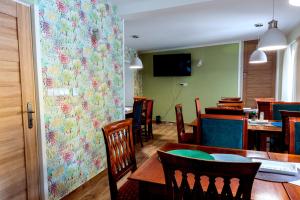 a dining room with tables and chairs and a floral wall at Vila Tess in Lázně Libverda