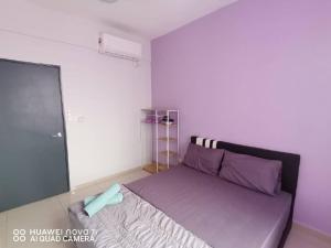 a bedroom with a large bed with purple pillows at HK Homestay in Ipoh
