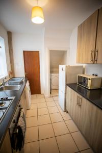 uma pequena cozinha com um lavatório e um frigorífico em Sigmalife Apartment em Newcastle upon Tyne